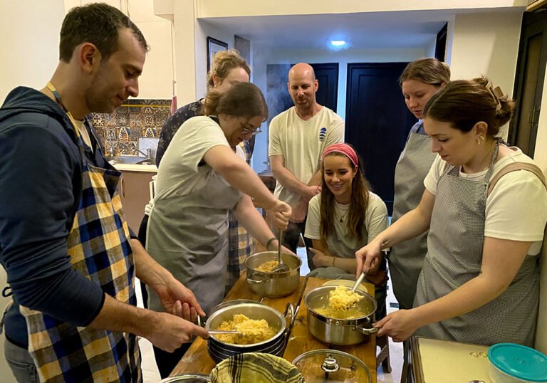 Big group making Indian dishes from scratch