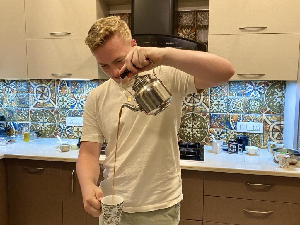 Guest pouring Masala Chai Tea in Cup