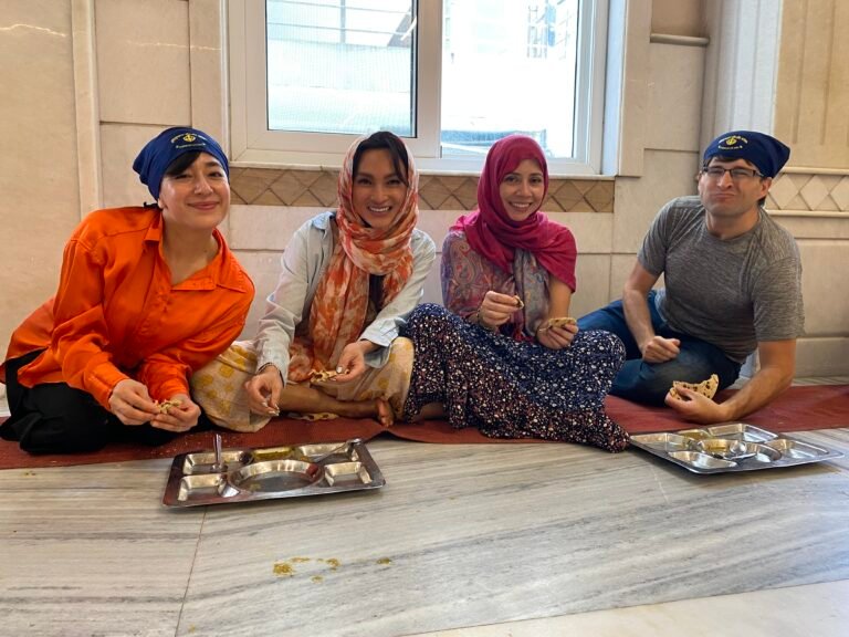 Tourists sharing food old delhi sikh temple kitchen scaled