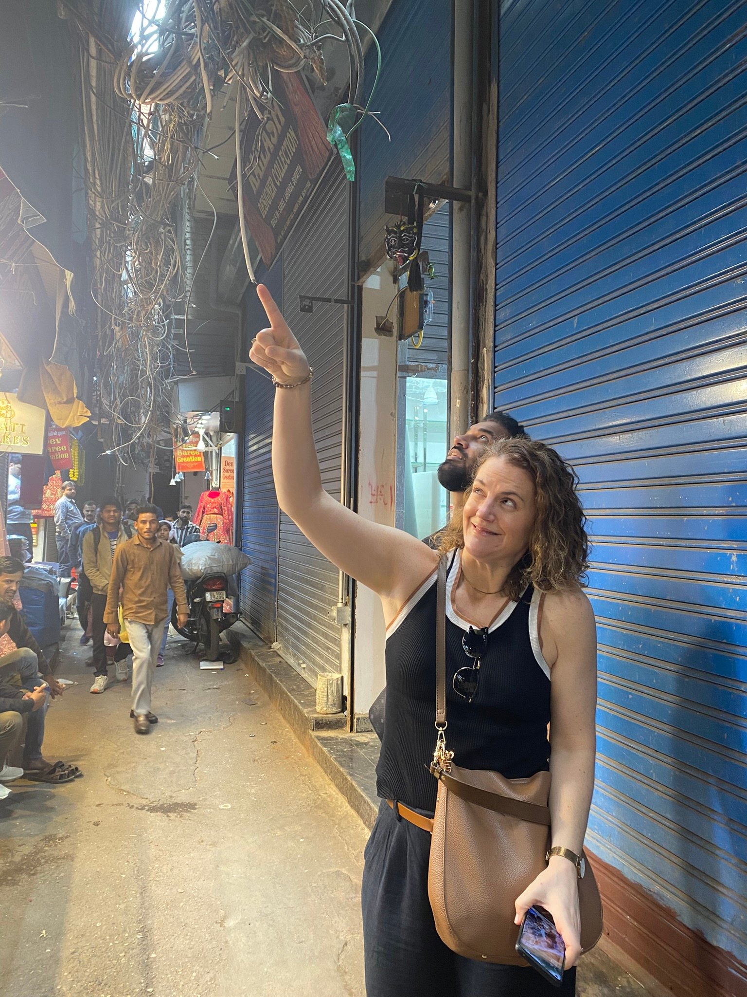 Foreign traveler discovering the chaotic cable wires and architecture of Old Delhi lanes