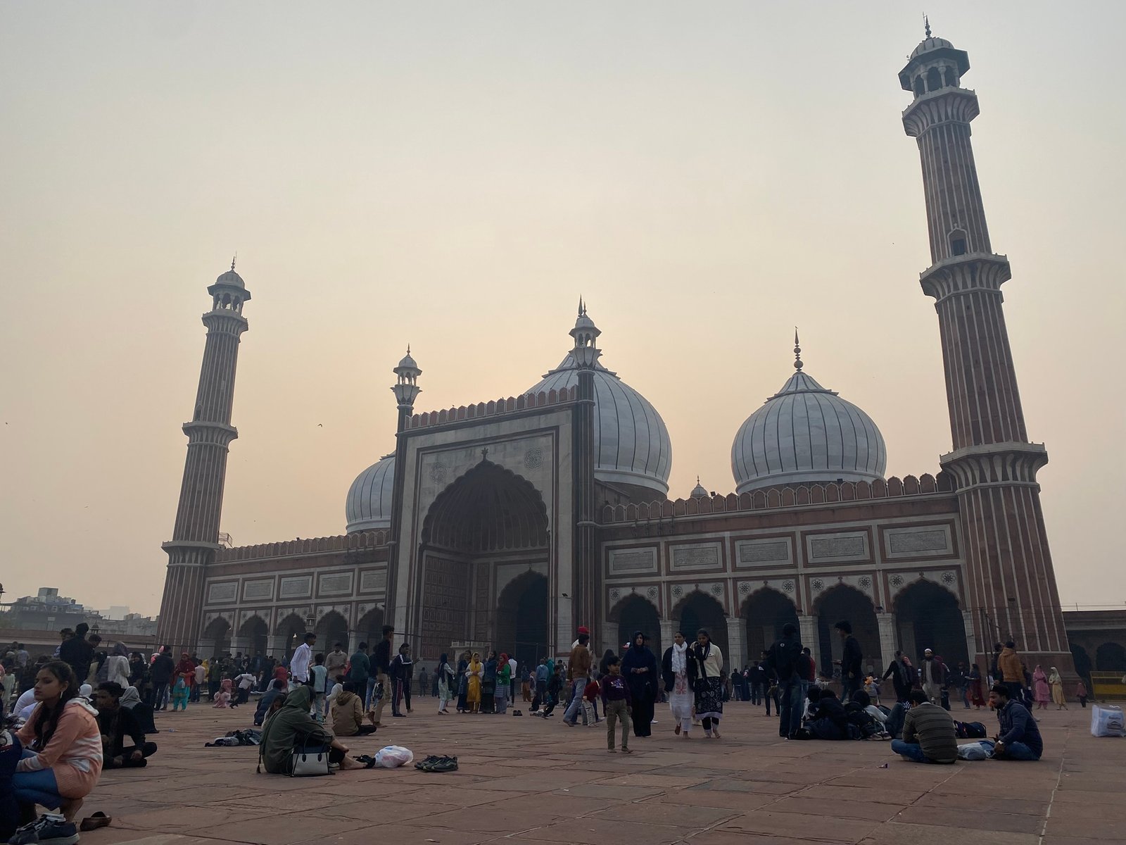 Front facade of Jama Masjid showing red sandstone and white marble minarets