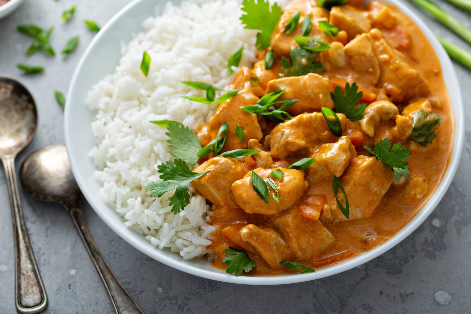 Butter chicken curry with cashew red gravy served with rice, a classic North Indian dish