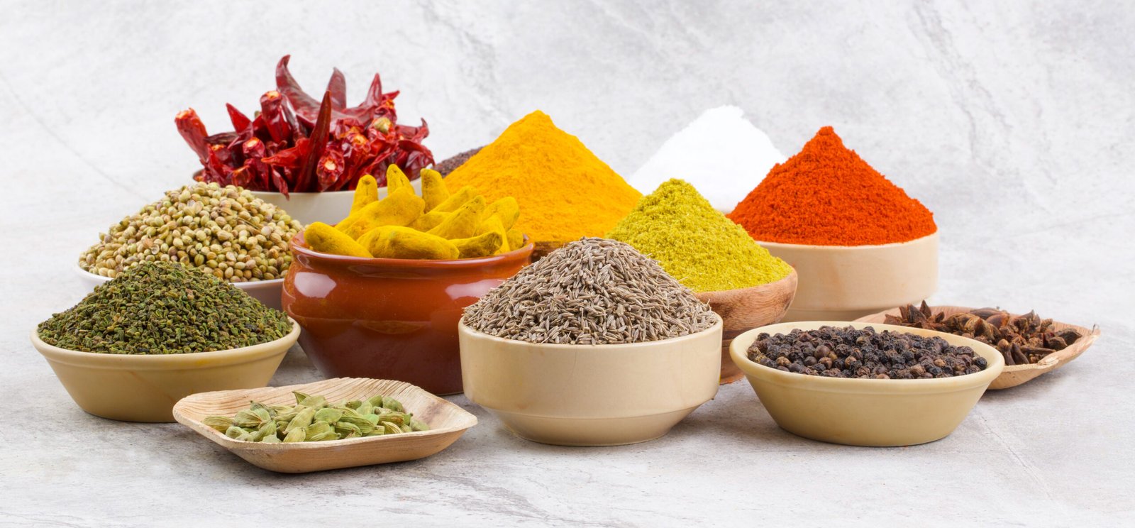 Collection of essential Indian spices including turmeric, chili powder, cumin and cardamom