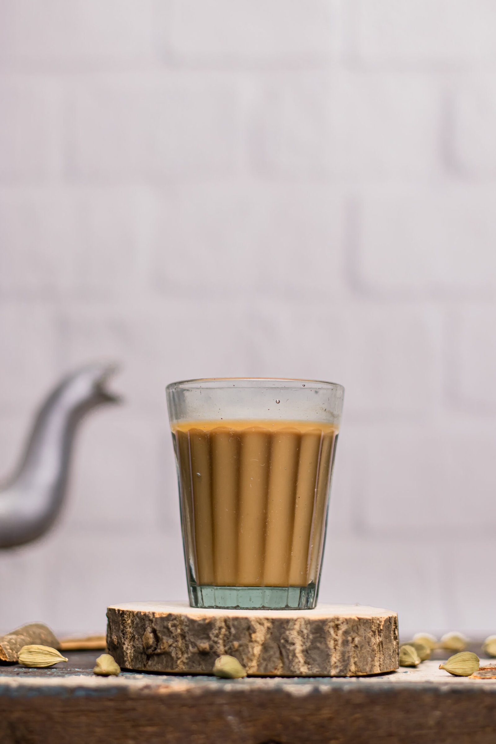 Indian chai served in glass cups with kettle and spices used to brew masala tea