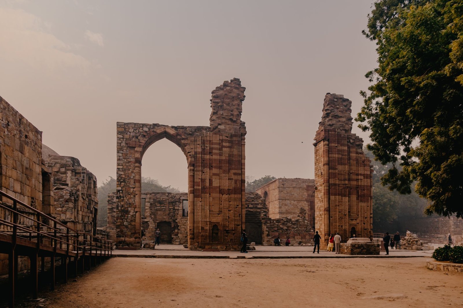 Interior grounds of Qutub Minar complex with mosque ruins and green lawns