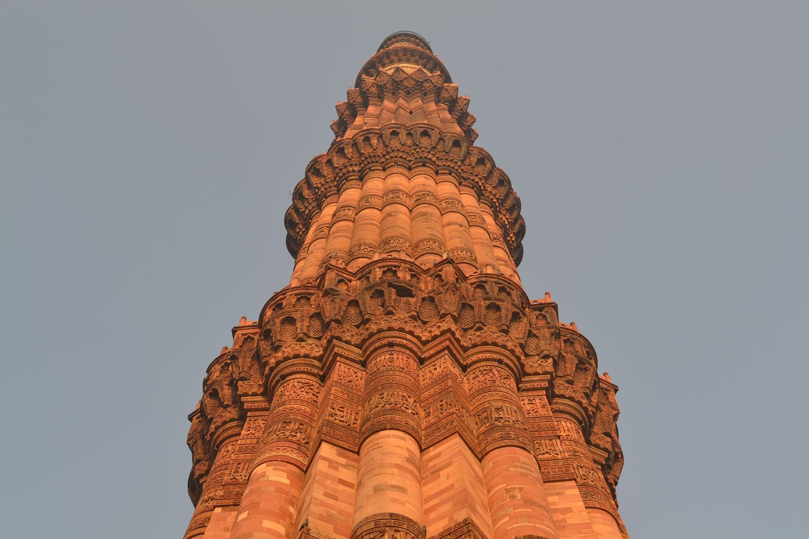 Qutub Minar tower viewed from ground level showing full height and carved sandstone