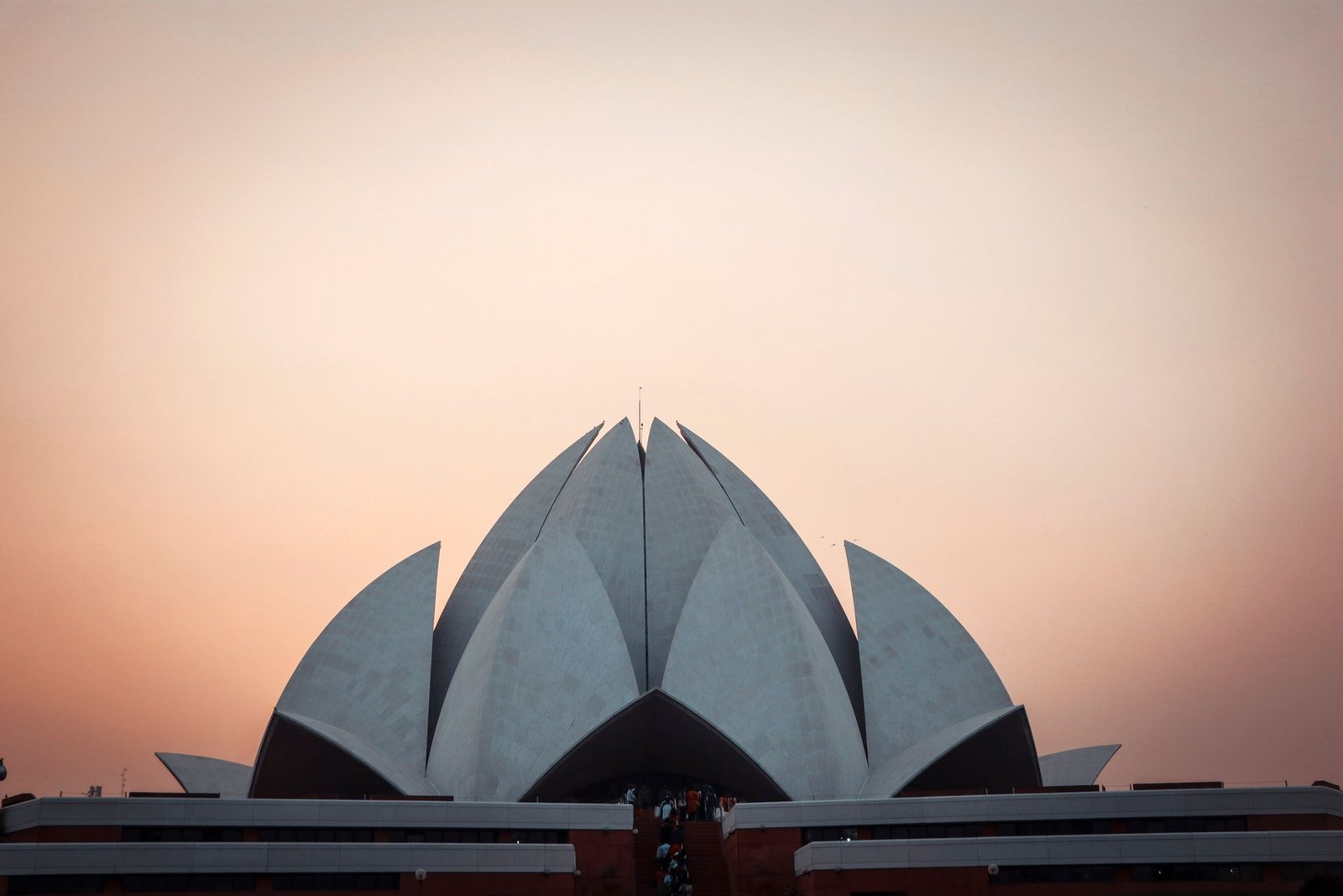 Lotus Temple at sunset with a pink sky in the background
